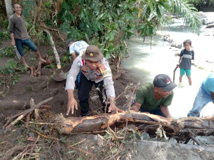 Pasca hujan Deras, Bhabinkamtibmas dan Warga Bersihkan Material Longsor di Jembatan Waemaras