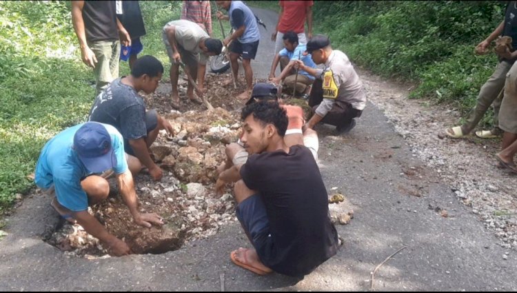 BHABINKAMTIBMAS REOK BARAT BERSAMA WARGA GELAR KERJA BHAKTI TAMBAL JALAN DI KAMPUNG RUMUNG