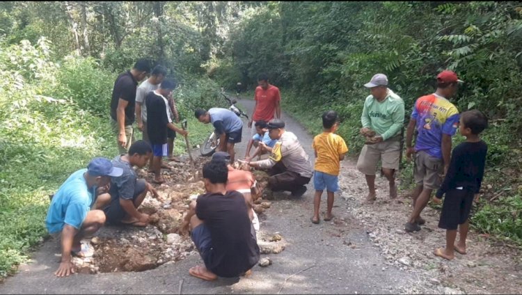 BHABINKAMTIBMAS REOK BARAT BERSAMA WARGA GELAR KERJA BHAKTI TAMBAL JALAN DI KAMPUNG RUMUNG